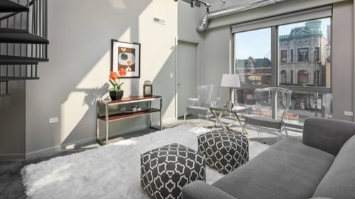 Spacious living room with spiral staircase to loft.