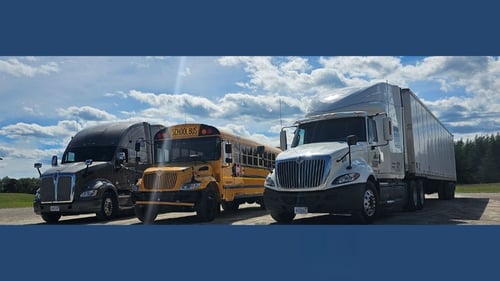 two trucks and a school bus parked next to each other