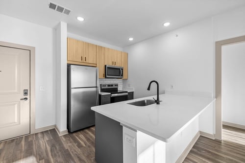 A kitchen with a white counter top and a black faucet at The River in Chester, VA, 23836