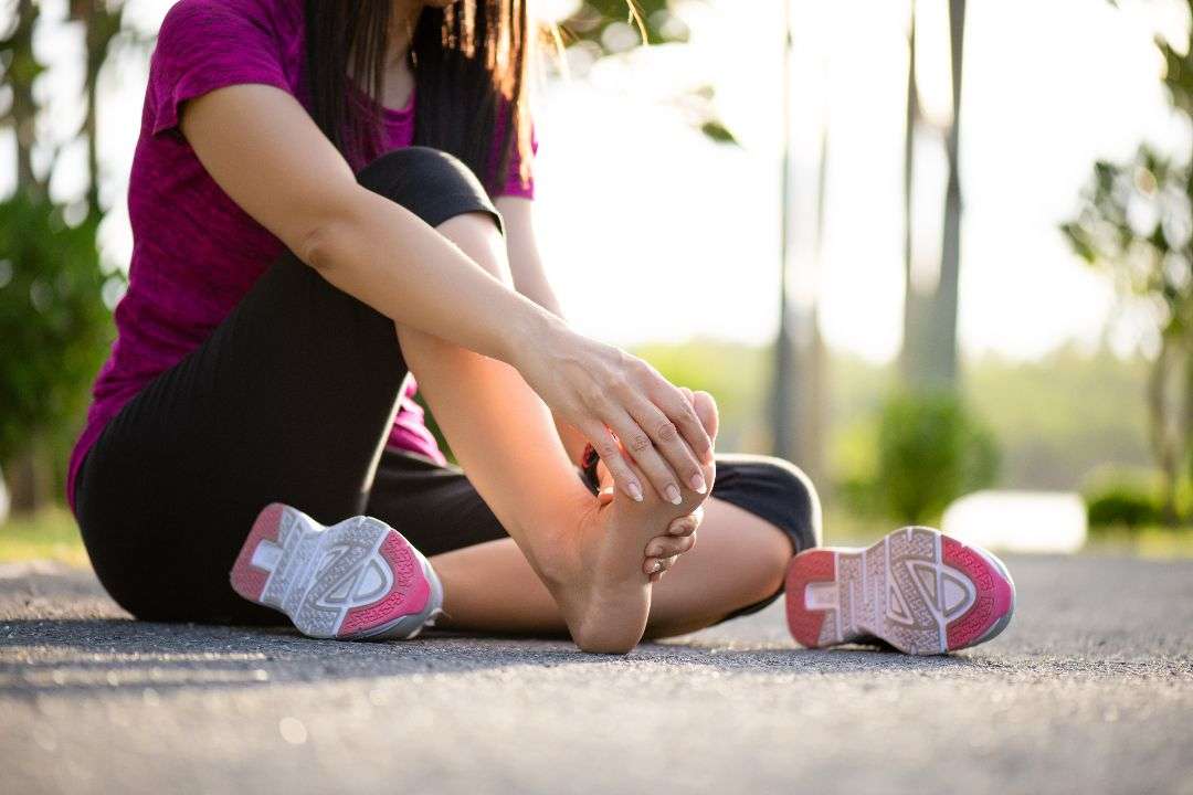 person outside experiencing foot pain during physical activity