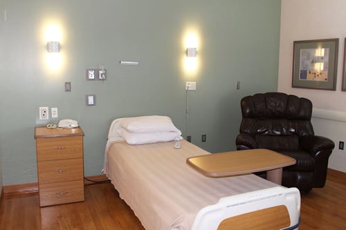A view of the postpartum room for after labor and delivery showing a bed and recliner
