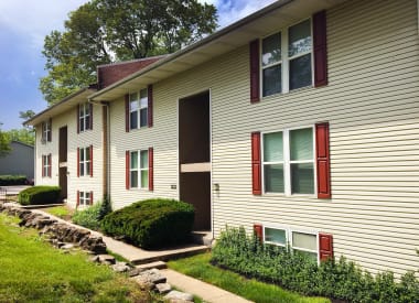 a yellow house with red window shutters and a green yard  at Timber Ridge Apartments, Cincinnati