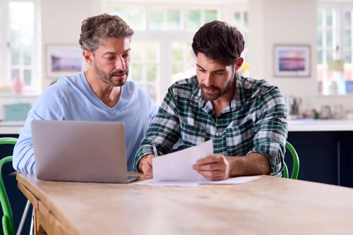 Couple discussing paperwork at kitchen table