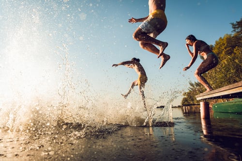 kids jumping into the water from a dock