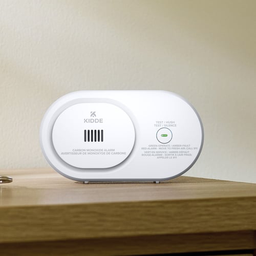 A carbon monoxide detector sits on a table.