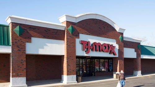 Person with shopping bag leaving exterior of T.J. Maxx at Westgate Plaza shopping center
