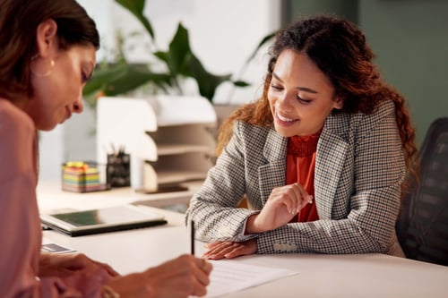 business women watching a women write on paper