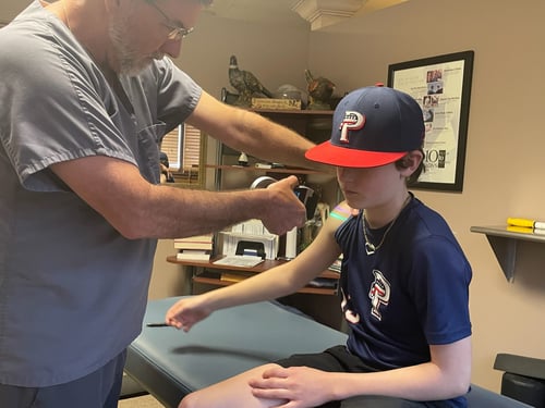 A person getting laser therapy at Ozark Mountain Chiropractic in Rogers, Arkansas
