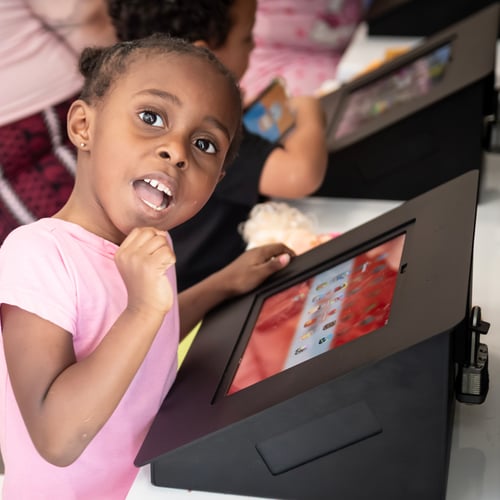 Child using a tablet in the kids' area at Speed Queen Laundry