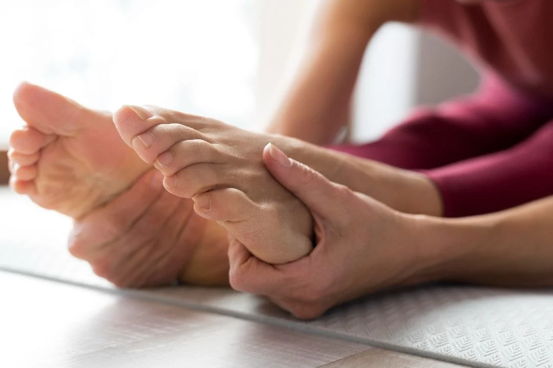 woman holding feet while stretching