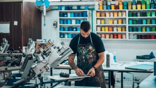 man working with a screen printing machine