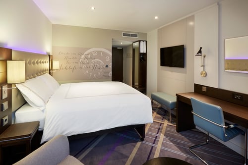 Premier Inn Germany room with large screen tv, desk, chair and tea/coffee-making facilities