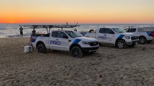 Pro 1 Pest Control work trucks on the Outer Banks' four-wheel drive beach