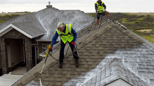 two employees working on a roof