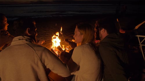 Du monde autour d'un feu de camp la nuit