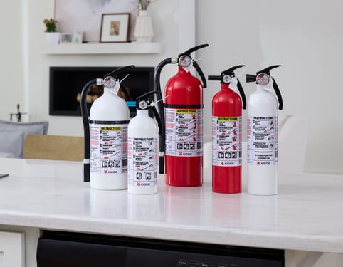 A group of Kidde Fire Extinguishers sit on a kitchen counter.