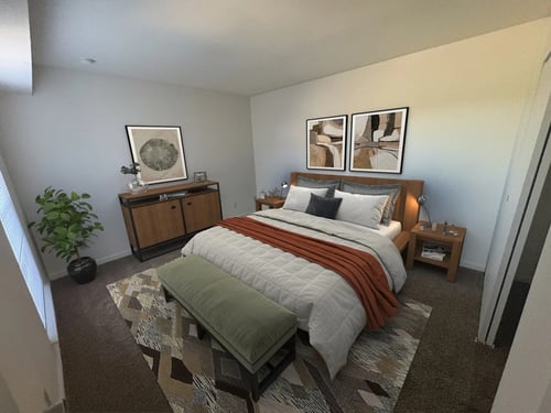 A bedroom with a bed, a bench, and a plant at Rivers Edge Apartments and Townhomes, Dayton, OH