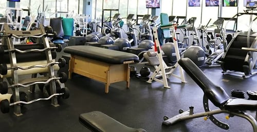 Member using strength training equipment on the fitness floor at The Club at Harper's Point gym in Cincinnati, OH
