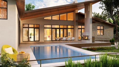 A modernist house lit from within with gold light and a large square pool in the yard.