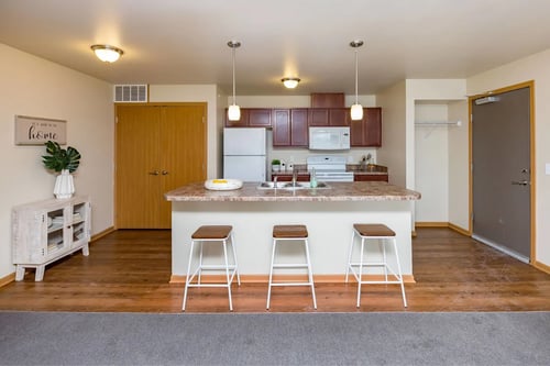 a kitchen with a large island with three bar stools at Melbourne Apartments, Iowa, 50320