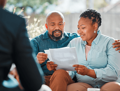 A couple meeting with an advisor and reading documents.