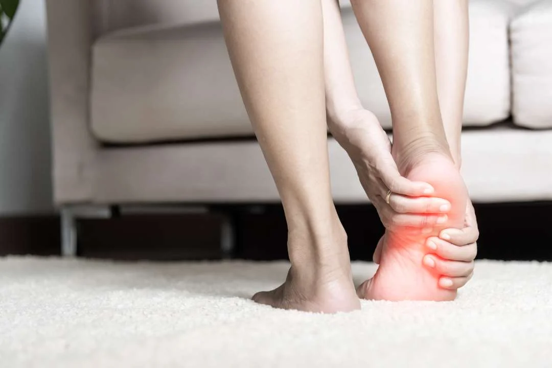 asian woman standing feeling pain her foot home