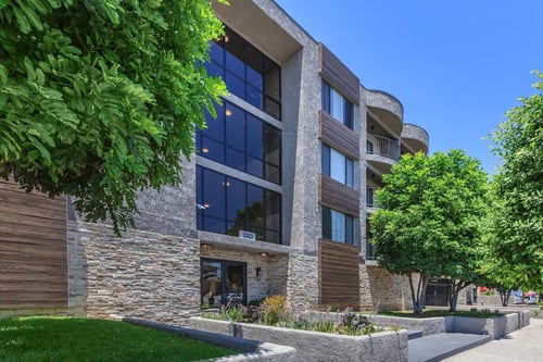A modern building with a stone facade and a glass entrance at Lafayette in Los Angeles, CA, 90019