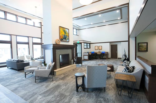 The Lodge, a separate building for residents, features a great room with comfortable furniture, plenty of seating, a two-sided fireplace, televisions and a business center.
