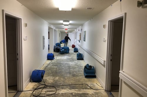 A Restoration 1 of Horry County technician places drying equipment in a hallway after a commercial water damage loss in North Myrtle Beach.