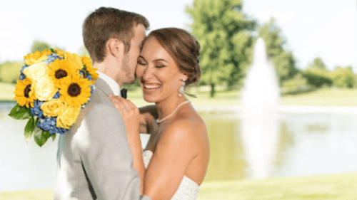 bride and groom in front of a pond