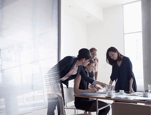 Four business women working at a table.