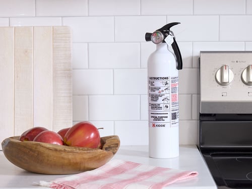 A Kidde kitchen fire extinguisher sits on a counter