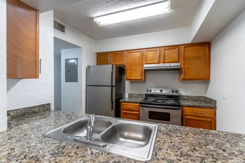 A kitchen with granite countertops and stainless steel appliances. at Academy on Dean Woods Apartments, Orlando, FL, 32825