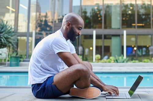 Man using free Wi-Fi next to a swimming pool