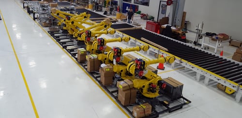 Fanuc robots staged in assembly area, laser welding line, stamped blank handling