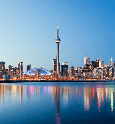 The Toronto city skyline in the evening with reflections in the water.