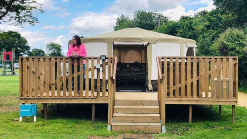 A canvas yurt at Moreton-in-Marsh. Grass leading up to the wooden steps on the balcony towards to yurt entrance.