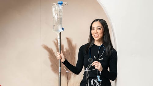 Owner of Revive & Hydrate posing next to an IV setup