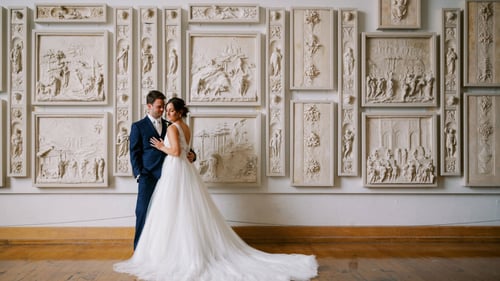 Bride and groom standing in front of a wall with an intricate design