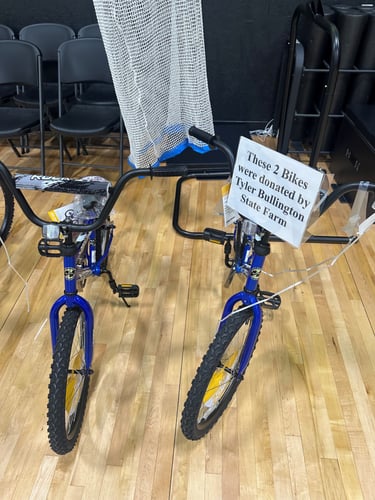 Two blue and black bikes on a hardwood floor