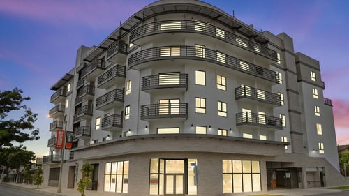 a large grey building with many windows and balconies at The Fairfax Flats Apartments, Los Angeles, CA