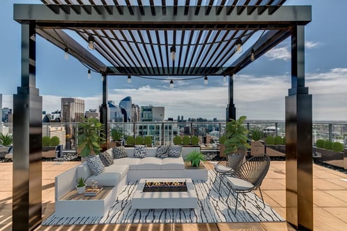 Versus in Calgary rooftop gazebo seating area with white couches and pillows