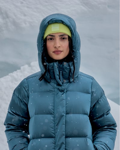 Woman in a puffer jacket in the snow.