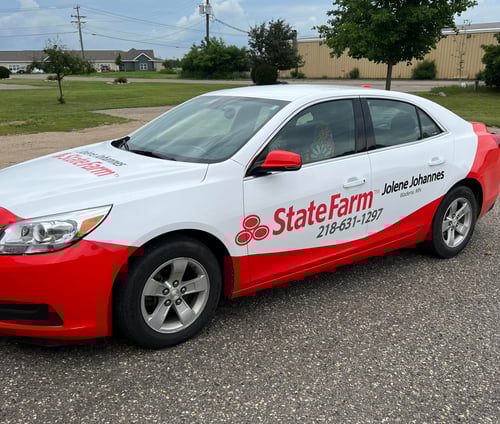 White and red State Farm car parked in parking lot