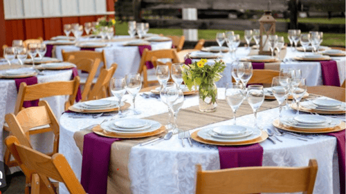 Round table with various plates, glasses, and silverware on it
