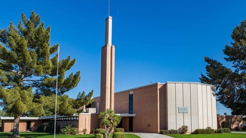 Mid-Century Modern brick church building with tall stand-alone spire
