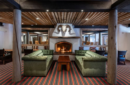 Living Room Lounge with green couches and fireplace