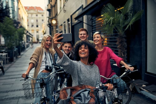 Group of friends riding bikes taking a picture on a phone