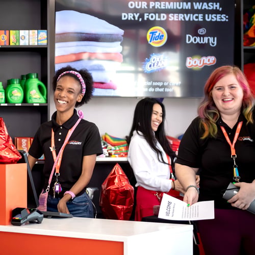 Speed Queen Laundry attendants smiling behind the service counter