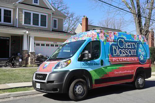 Cherry Blossom Plumbing van parked in front of a house